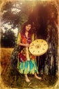 Beautiful shamanic girl playing on shaman frame drum in the nature, old photo effect. Royalty Free Stock Photo