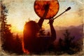 Beautiful shamanic girl playing on shaman frame drum in the nature, old photo effect. Royalty Free Stock Photo