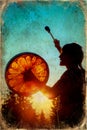 Beautiful shamanic girl playing on shaman frame drum in the nature, old photo effect.