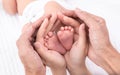 Beautiful shape hands of father, mother, hold tiny newborn baby feet leg on white bed with love, care, family safety and Royalty Free Stock Photo