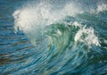 A breaking blue green wave rolling in towards shore