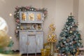 Beautiful shebby chic cupboard decorated with artificial snowy fir branches, icy roses, rocking horse toy, golden Christmas