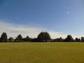 Beautiful shimmering creamy blue sky over flowing park land