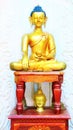 Beautiful shining classical Buddha Shakyamuni Siddhartha Gautama golden statue with open eyes on the white