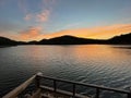 Beautiful shining golden, orange sunset reflected on surface of undulating lake on summer evening