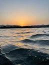 Beautiful shining golden, orange sunset reflected on surface of the undulating sea on summer evening