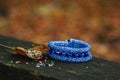 Beautiful, shiny, color bracelet with large beadwork beads. On a special stand for jewelry. Beads are scattered on a wooden table Royalty Free Stock Photo