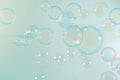 Beautiful shiny transparent colorful green soap bubbles floating background.