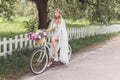 beautiful shocked bride in wedding dress riding bicycle