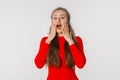 Beautiful shocked and surprised woman with open mouth. Amazed girl holds cheeks by hand, stand over white studio background. Royalty Free Stock Photo