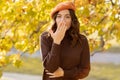 Beautiful shocked woman walking outdoors in autumn, looking at camera covering her mouth with hand Royalty Free Stock Photo