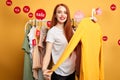 Beautiful shop assistant offers clothes to customers