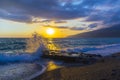Beautiful shoreline scene with waves at sunset beams