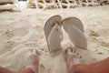 Beautiful shot of Bare feet and sandals in the sand on the beach Royalty Free Stock Photo