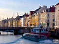 Beautiful shot of boats sailing in a canal along colorful buildings in Nyhavn, Copenhagen, Denmark Royalty Free Stock Photo