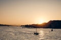 Beautiful shot of boats sailing on the sea with buildings on the hill in the distance