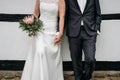 Beautiful shot of the bride holding hands with the groom and  a bouquet of flowers in the other hand Royalty Free Stock Photo