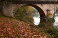 Beautiful shot of a bridge reflecting on a river surface during autumn Royalty Free Stock Photo