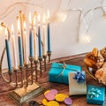 Beautiful shot of a burning Menorah lampstand next to pastry in celebration of Hanukkah