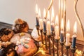 Beautiful shot of a burning Menorah lampstand next to pastry in celebration of Hanukkah