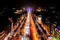Beautiful shot of cars driving in the middle of buildings with lit lights in Paris, France