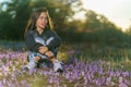 Beautiful shot of a Caucasian little girl sitting in a field full of purple flowers