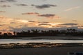 Beautiful shot of the clouds over the calm lake with palm trees on the background Royalty Free Stock Photo