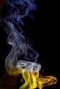 Beautiful shot of a colorful cone incense smoke trails isolated on black background