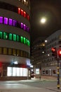 Beautiful shot of empty crossroads and buildings with colorful windows at night