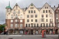 Beautiful shot of the facade of historic wooden buildings in Bergen with a telephone booth in front