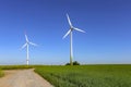 Beautiful shot of a field with electric windmills under a bright blue sky Royalty Free Stock Photo