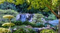Beautiful shot of a flowing rocky waterfall in a lush Japanese garden Royalty Free Stock Photo