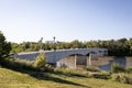 Beautiful shot of a footbridge over a river surrounded by trees and fields in a park Royalty Free Stock Photo