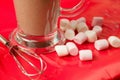 Beautiful shot of a glass of chocolate milkshake and marshmallows on a red table