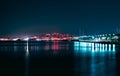 Beautiful shot of glowing blue and red lights across the water in Faliro, Greece