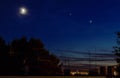 Beautiful shot of a glowing moon with a visible jupiter and venus seen in a night-blue sky