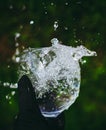 Beautiful shot of the hand holding a glass of fresh water with a splash Royalty Free Stock Photo