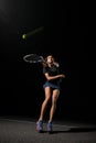 beautiful shot of healthy woman with tennis racket in her hand bouncing to hit the tennis ball. Royalty Free Stock Photo