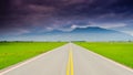 Beautiful shot of a highway in the middle of green fields Royalty Free Stock Photo