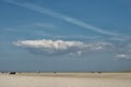 Beautiful shot of a huge isolated cloud hanging in the pure sky above the sandy shore