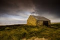 Beautiful shot of an isolated fisherman`s hut in a valley next to the shore of the sea in Ireland Royalty Free Stock Photo