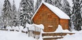 Beautiful shot of a log house covered with snow on a cold winter day in the forest Royalty Free Stock Photo