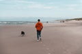 Beautiful shot of a man with his dog running on a beach Royalty Free Stock Photo