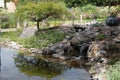 Beautiful shot of a man-made small waterfall over a rocky pond in the park