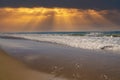 A beautiful shot of miles of vast blue ocean water and waves rolling into a beach with silky brown sand with powerful clouds Royalty Free Stock Photo