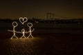 Beautiful shot of a neon sign of a family placed by a bridge in the evening