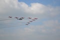 Beautiful shot of nine warplanes and a helicopter in the sky going in the same direction.