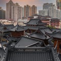 Beautiful shot of an old Buddhist temple rooftop against skyscrapers of Shanghai, China Royalty Free Stock Photo