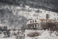 Beautiful shot of an old ruined stone house on the valley during the winter covered in snow Royalty Free Stock Photo