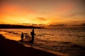 Beautiful shot of a parent and a child entering the sea during the sunset